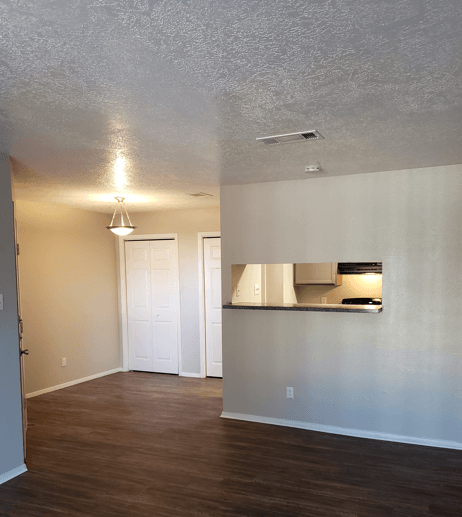 A room with a white door and a light on the ceiling.